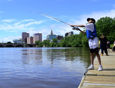 A young man fishing on the dock at Riverside Park